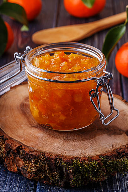 istock Orange (tangerine) jam in a glass jar on the table. 512510586