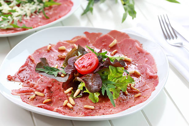 Beef carpaccio Beef carpaccio with rucola and pine nuts carpaccio parmesan cheese beef raw stock pictures, royalty-free photos & images