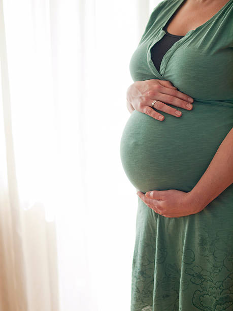 istock Pregnant young woman holding her belly 512521493