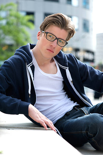 istock Young guy with glasses sitting outdoors 512521573