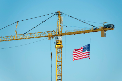 yellow industrial big crane with american flag