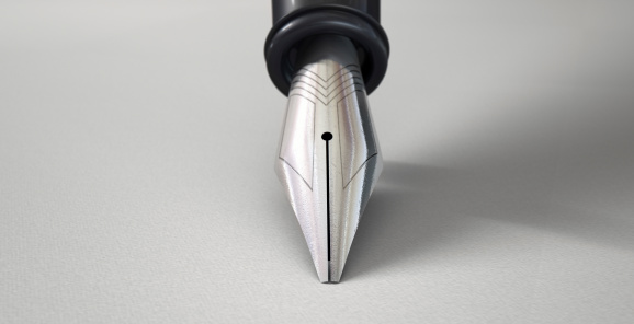 A closeup view of the tip of a fountain pen resting in a drawing position on a textured white paper background