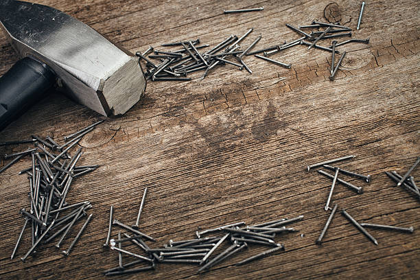 istock chrome Hammer and nails on wooden board 512522898