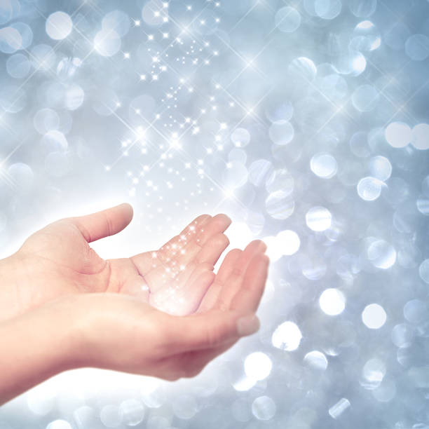 Hands catching stardust Hands catching stardust in front of a frosty, wintry background funkeln stock pictures, royalty-free photos & images