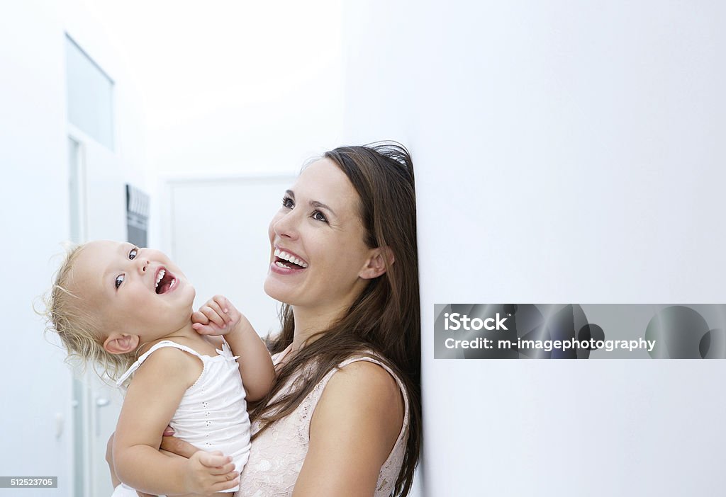 Mother and baby girl laughing together Close up portrait of a mother and baby girl laughing together 12-17 Months Stock Photo