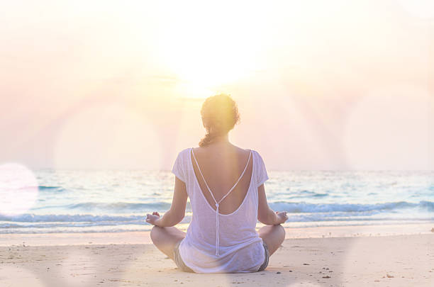istock woman practicing yoga at sunrise beach 512524290