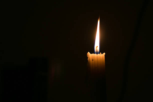 istock Candle light burning in dark room 512536956