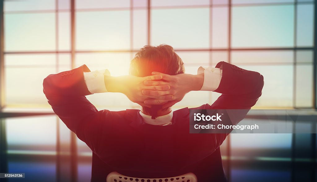 Satisfied with work done Satisfied with work done. Happy young business man looking out windows in office. Relaxation Stock Photo