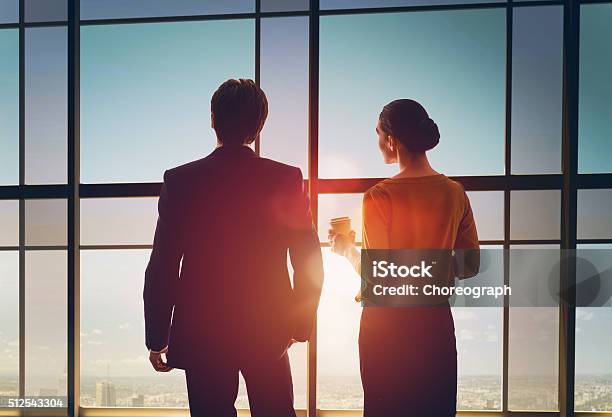 Man And Woman Look At The City Stock Photo - Download Image Now - Looking Through Window, Businessman, Women