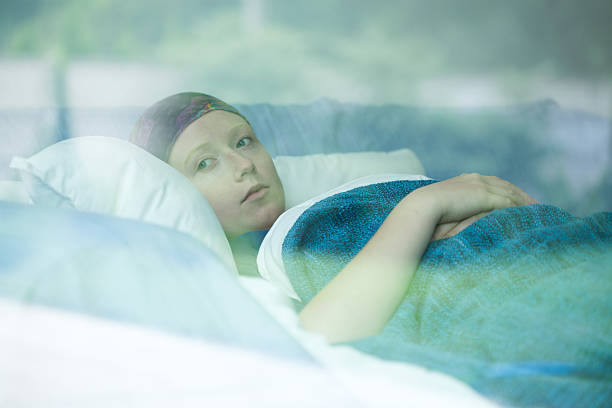 Young woman suffering from cancer Young woman in bed suffering from cancer hospital depression sadness bed stock pictures, royalty-free photos & images