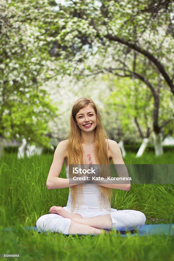 yoga time beautiful girl is doing yoga in the blossoming garden Activity Stock Photo