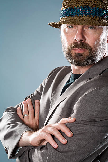 istock Mature businessman in summer hat against gray background 512546817