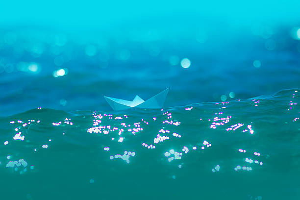 istock paper boat in the sea waves 512547117