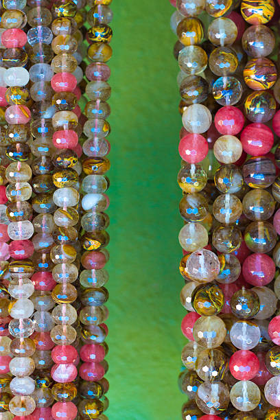 istock Bright Beads Hanging Against Lime-Green Wall (Close-Up) 512547167