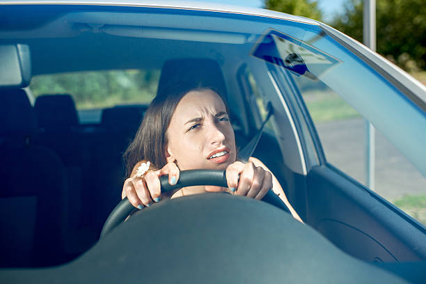 Young woman driving car. Windshield view