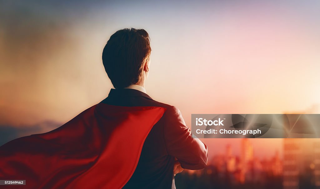 superhero businessman looking at city superhero businessman looking at city skyline at sunset. the concept of success, leadership and victory in business. Superhero Stock Photo