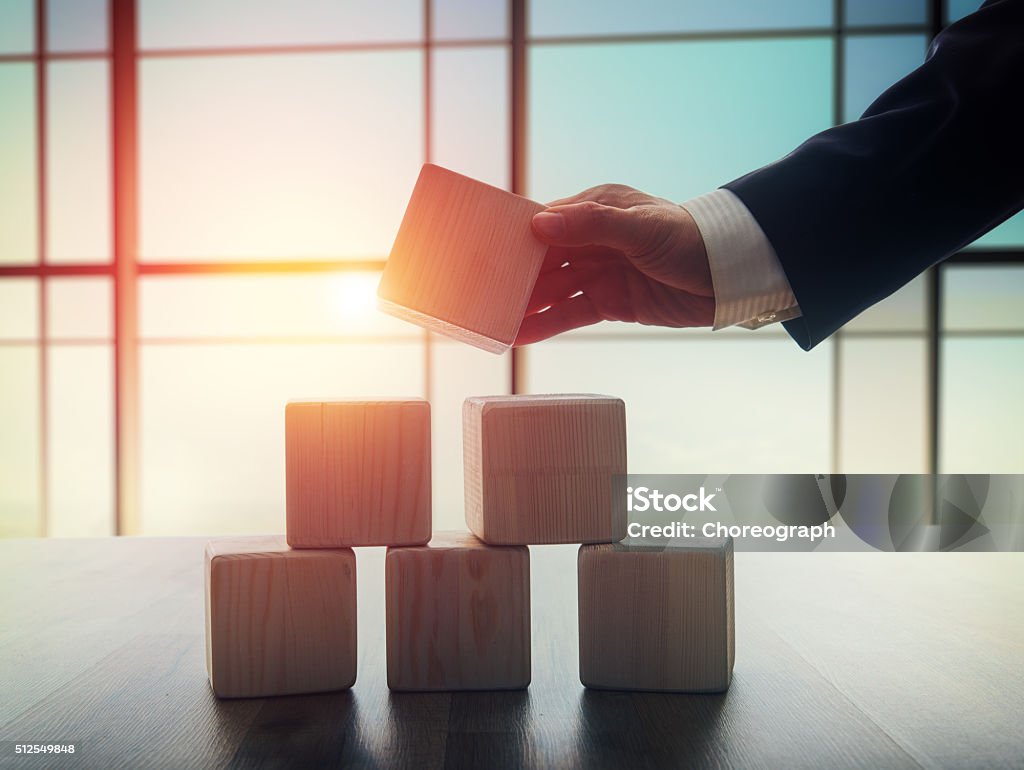 men holding the cubes The concept of planning in business. Wooden cubes on a desk in the office. The concept of leadership. Hand men in business suit holding the cubes. Wealth Stock Photo