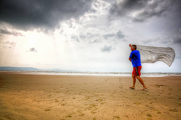 istock Senior man running on beach with silk scarf 512551951