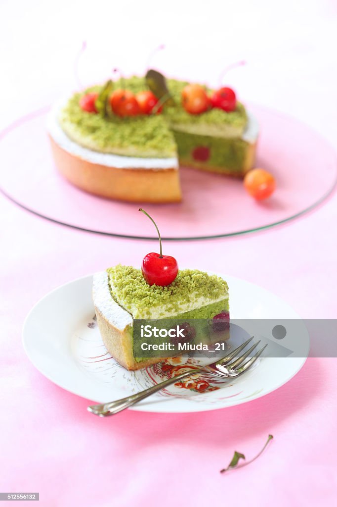 Pistachio Tart with Cherries Pistachio Frangipani Tart with Cherries on a light pink background. Cake Stock Photo