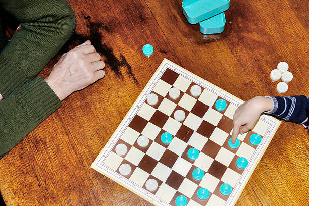 istock Grandfather and grandson are playing checkers 512556168
