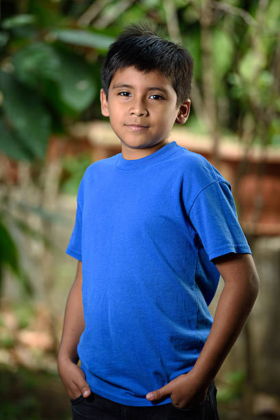 latino boy  in blue shirt with hands  in pocket