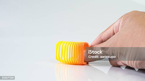 Hand Holding Elastic Spring Coil On Empty Background Stock Photo - Download Image Now