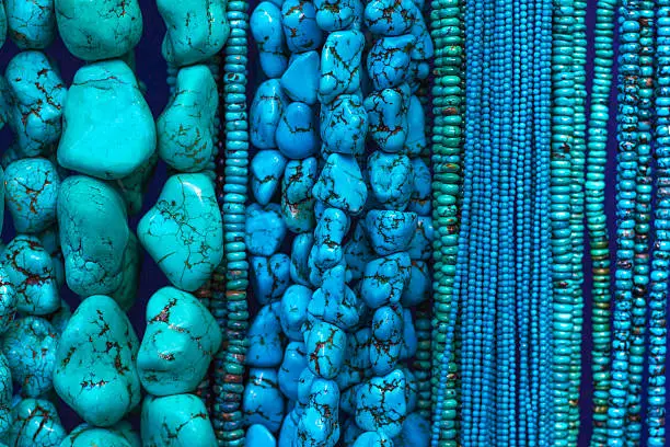Photo of Turquoise Beads and Necklaces Hanging in Shop (Close-Up)