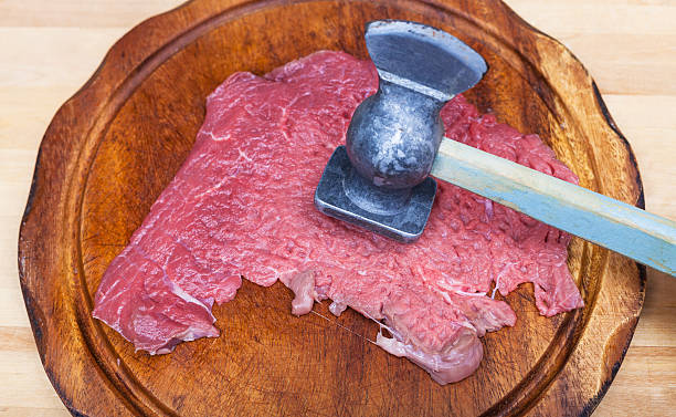 slice of veal are beat by meat tenderizer