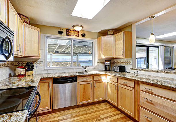istock Bright kitchen with granite tops and black appliances 512572727