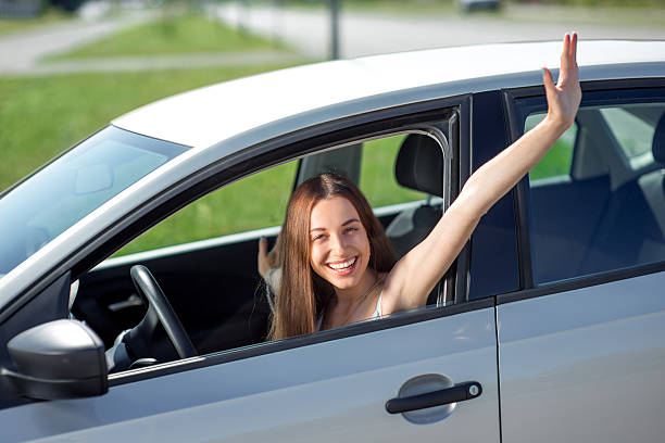 istock Young smiling woman driving her new car 512574333