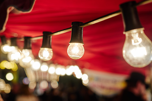 white fluorescent bulbs on funfair / bulbs under red fabric roof