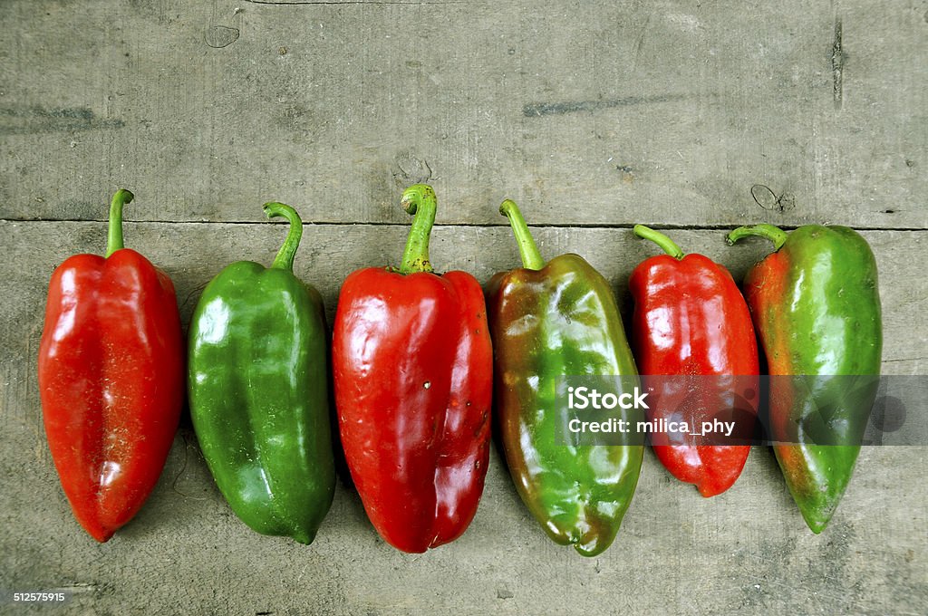 Red and green peppers Fresh red and green peppers on a wooden table Colors Stock Photo