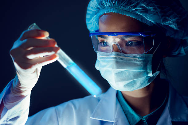 Fluorescent liquid Medical researcher holding test tube with blue fluorescent liquid medicine vial stock pictures, royalty-free photos & images