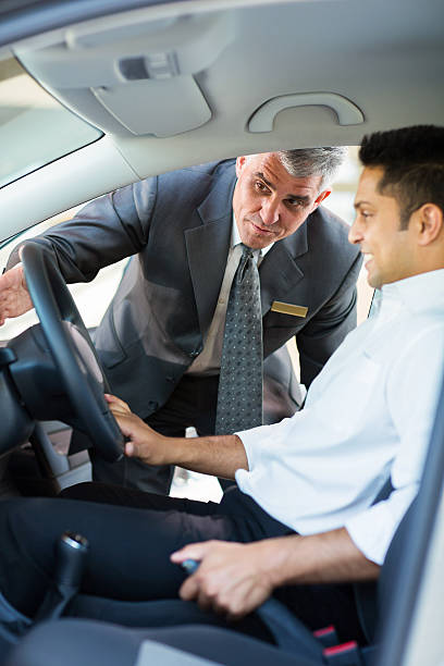 istock middle aged salesman showing new car interior to customer 512577929