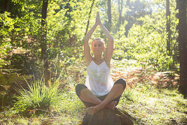 istock Young woman practicing yoga in nature at sunset 512578191