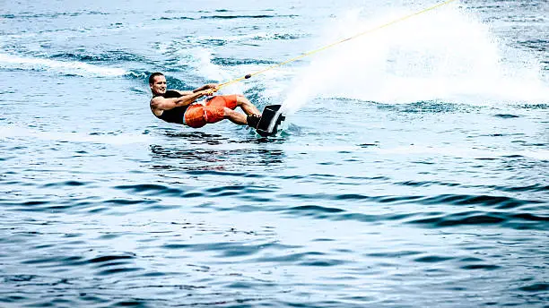 A wakeboarder cutting out on his toe-side edge.