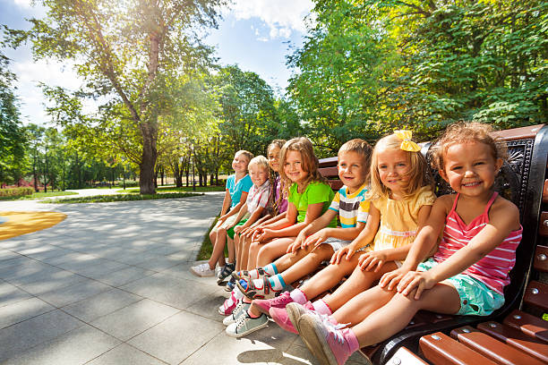 istock Cute kids on the bench in park toggether 512600275