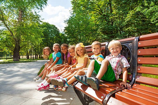 istock Group or kids rest on bench in park 512600379
