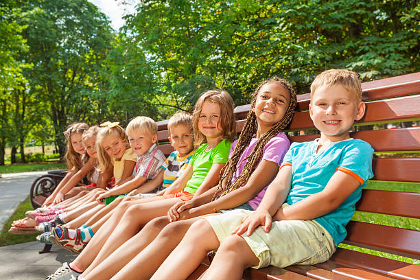 istock Happy children sit on the bench in park 512600453
