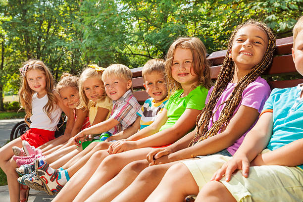istock Beautiful little children sit on bench in park 512600511