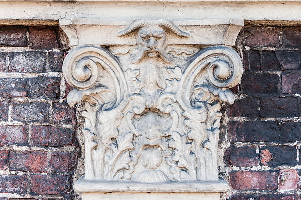 istock Ancient and scorched stone ornament with a demon face 512601003