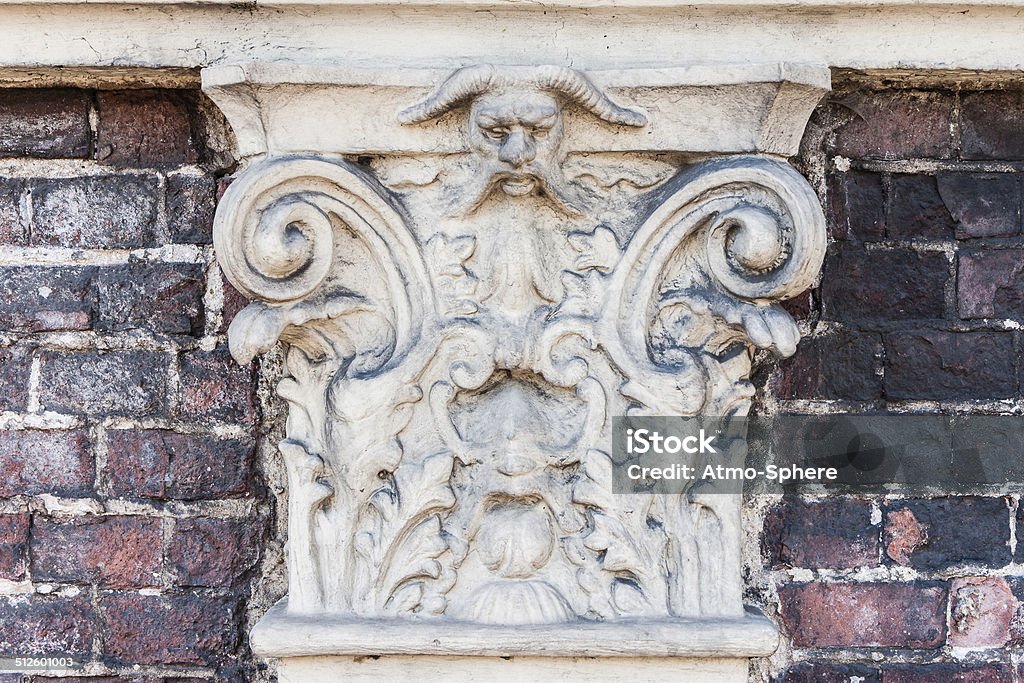 Ancient and scorched stone ornament with a demon face Ancient Stock Photo