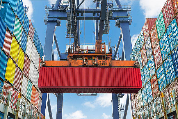 istock Shore crane lifts container during cargo operation in port 512603025