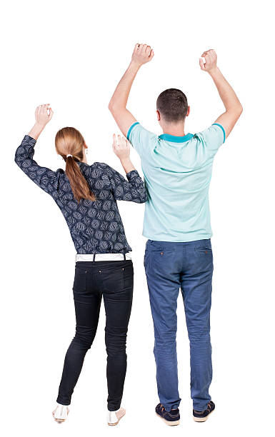 istock Back view of  joyful couple celebrating victory hands up. 512605199