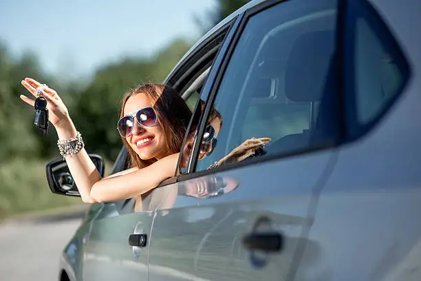 Photo of Car driver woman happy showing keys out window