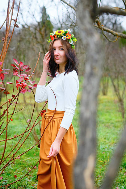 ブルネットの少女と花の豊かなリースで秋の公園 - russian culture women fashion model teenage girls ストックフォトと画像