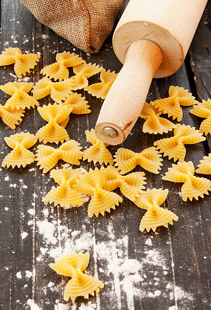 istock Uncooked pasta with flour on the table, selective focus 512622786