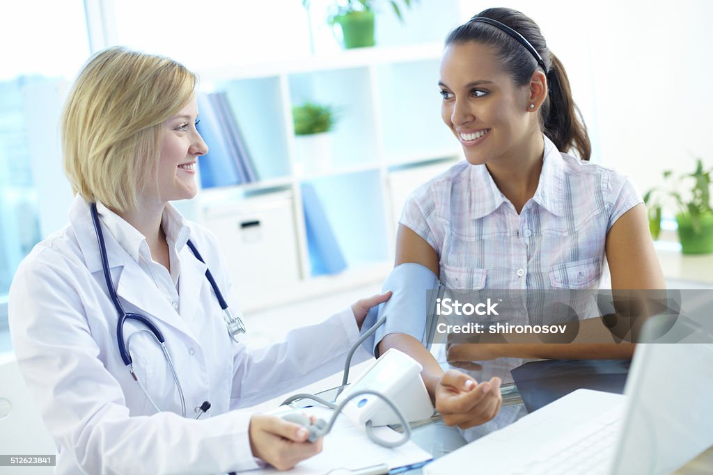 Measuring blood pressure Image of doctor measuring pressure of patient on tonometer Adult Stock Photo