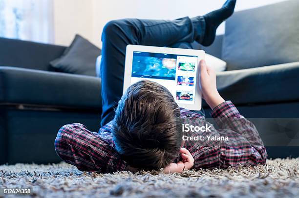 Adolescente Recuéstese En El Piso De La Habitación Foto de stock y más banco de imágenes de Niño - Niño, Tableta digital, Adolescente