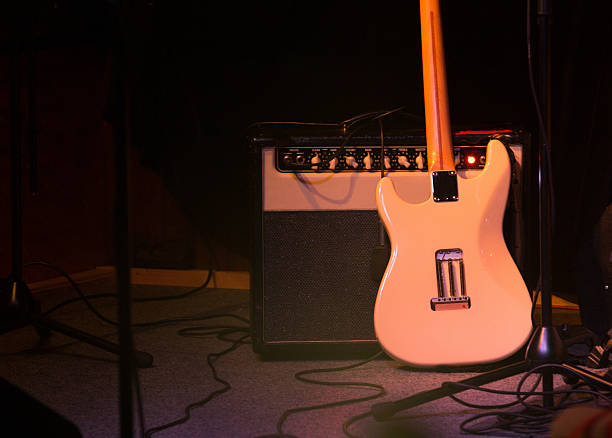 istock Guitar and  Amplifier on Stage , dark background 512627329